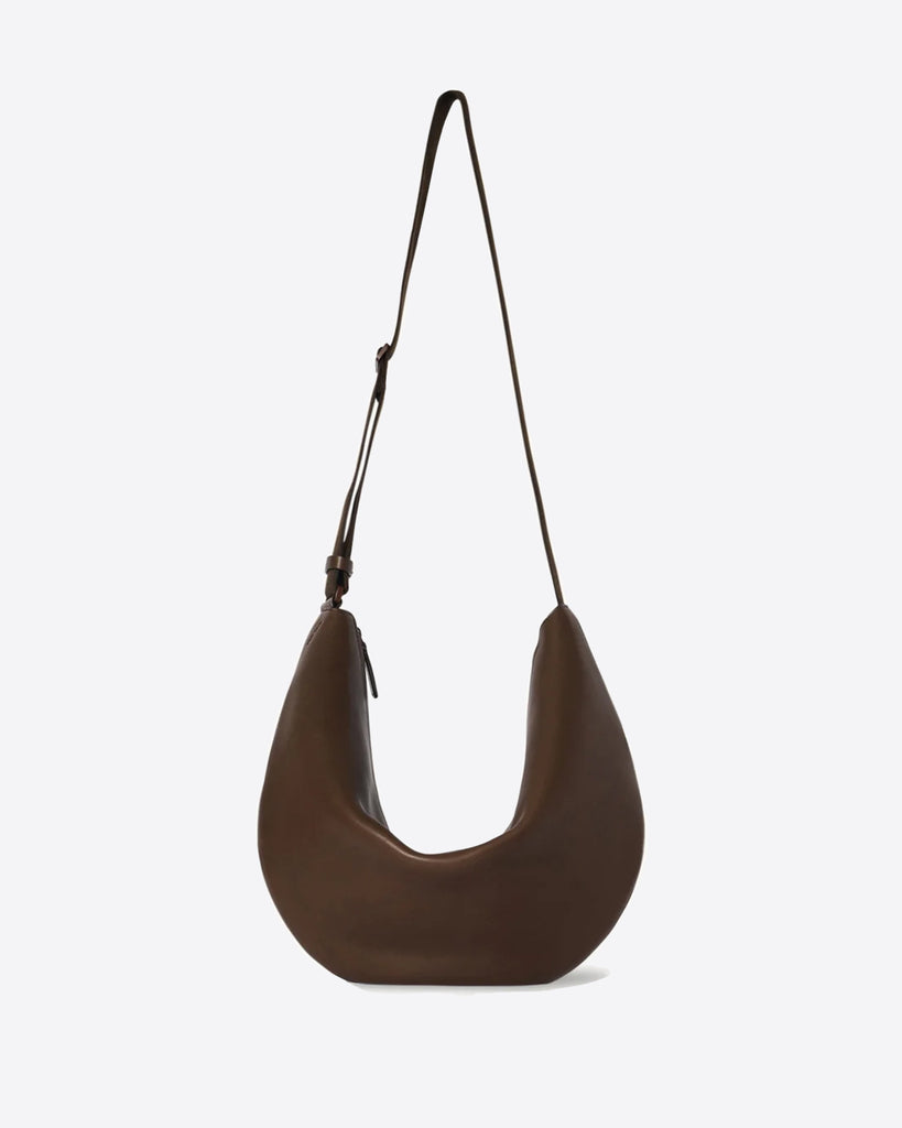 The Row Crossbody Crescent in dark brown